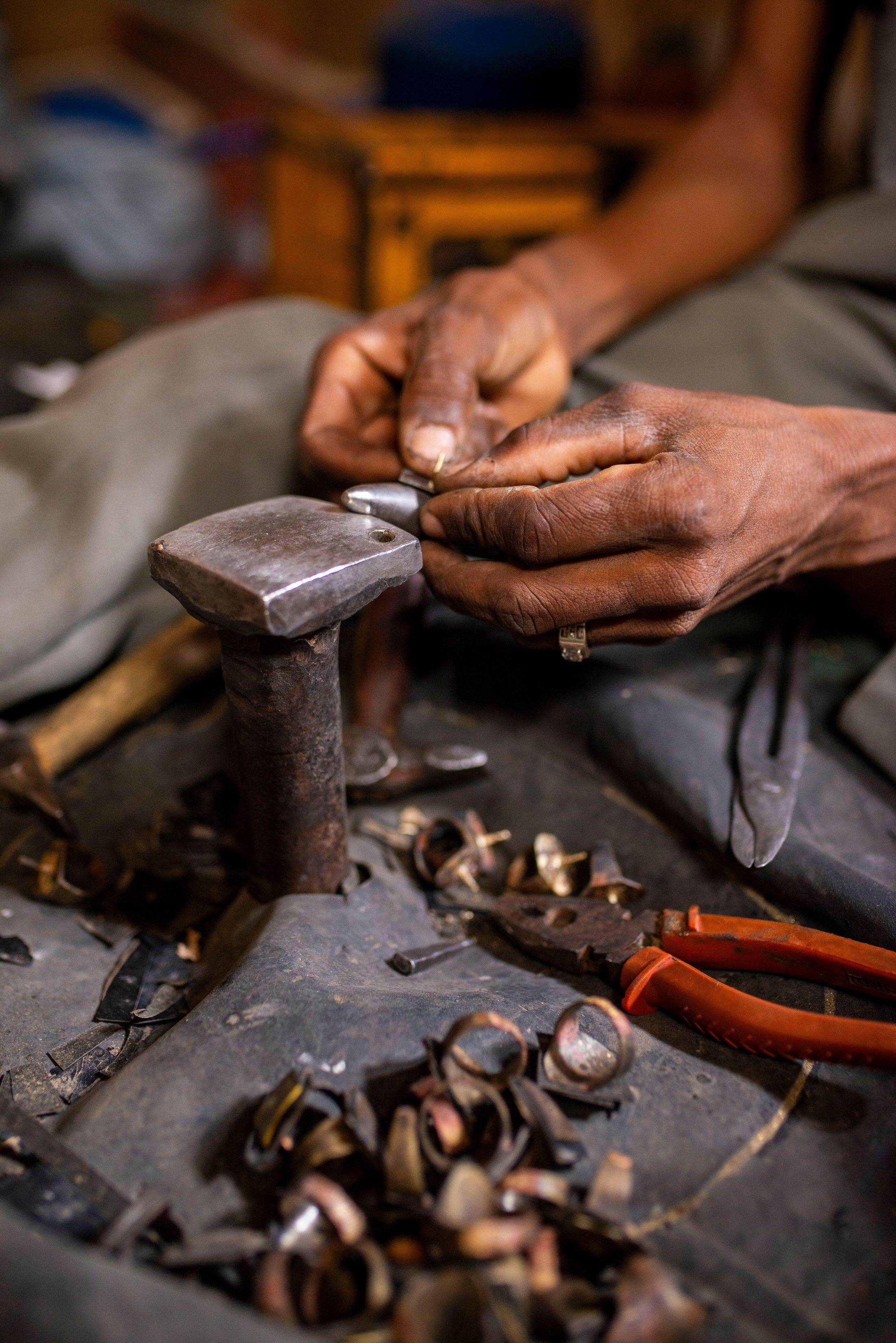 A craftsman’s hands shaping a piece of jewellery with traditional tools