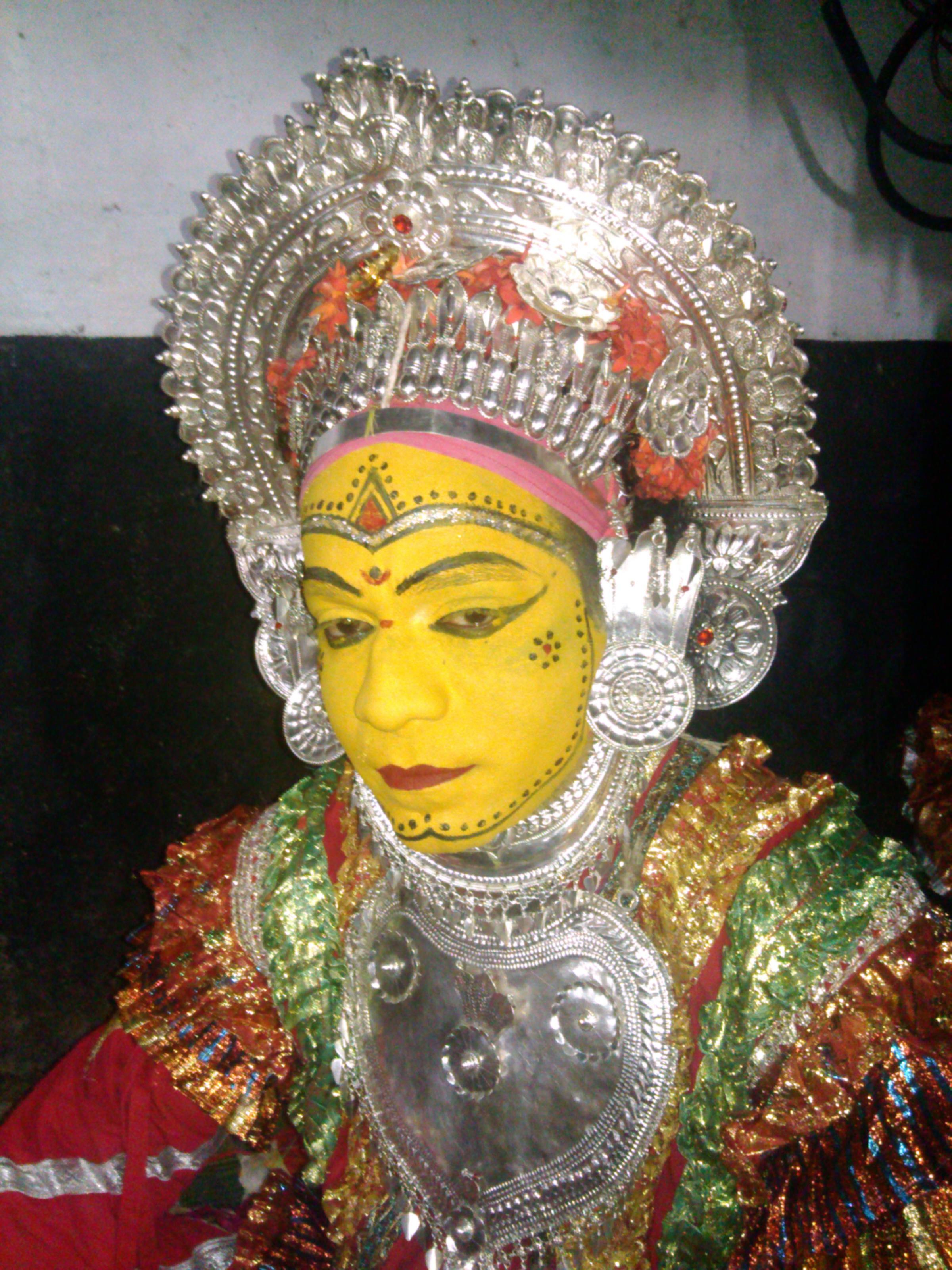 A Pilichamundi Daiva impersonator wearing a silver crown and silver breastplate ornaments
